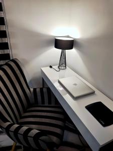 a desk with a laptop and a chair with a lamp at fruit tower 300Mbps in Thessaloniki