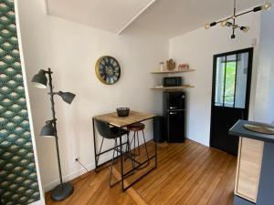 una habitación con una mesa y un reloj en la pared en Le Saint-André, Gare de Rouen, en Rouen