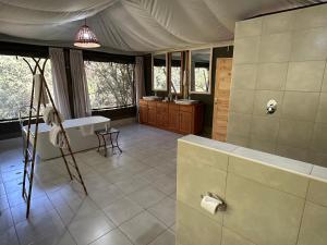 een grote badkamer met een bad en een wastafel bij Olesamara Collection in Nanyuki