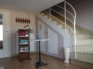 a room with a staircase and a table in front of a door at LES GRADINES in Bar-sur-Aube