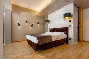 a bedroom with a large bed with lights on the wall at Serenity Resort in Codlea