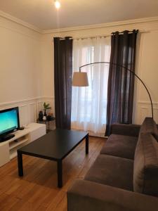 a living room with a couch and a coffee table at L'appartement Idéal 4 voyageurs in Boulogne-Billancourt