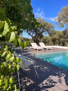 uma piscina com duas espreguiçadeiras ao lado de uma piscina em Casa Dos Galegos em Marvão