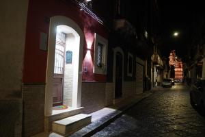 una calle estrecha por la noche con una ventana y escaleras en HAPPY HISTORIC HOUSE, en Catania