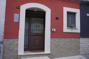 un edificio rojo con una puerta marrón y una ventana arqueada en HAPPY HISTORIC HOUSE, en Catania