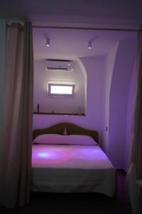 Un dormitorio con una cama con luces moradas. en HAPPY HISTORIC HOUSE, en Catania