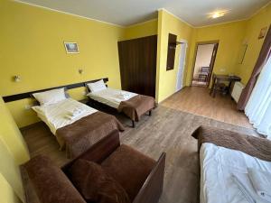 um quarto de hotel com duas camas e um sofá em Готель Цісар em Lviv