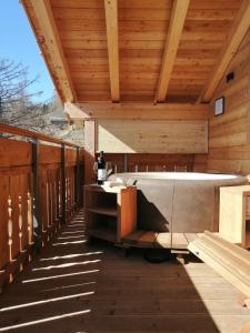 una vasca idromassaggio su una terrazza con soffitto in legno di Chalet Henne- Hochgruberhof a Selva dei Molini