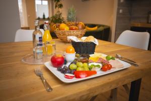 een bord groenten en fruit op een houten tafel bij 1880 Lofthaus & Apartmenthaus in Gera