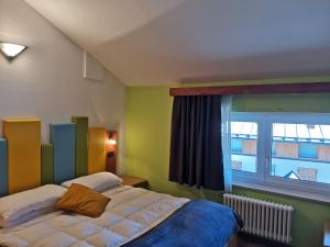 1 dormitorio con cama y ventana grande en Alpencolor Hotel Tonale, en Passo del Tonale