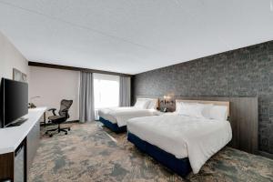 um quarto de hotel com duas camas e uma televisão de ecrã plano em Hilton Garden Inn Toronto/Brampton em Brampton