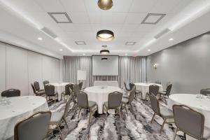 uma sala de conferências com mesas e cadeiras e um quadro branco em Hilton Garden Inn Toronto/Brampton em Brampton