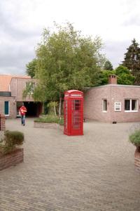 a red phone booth on a brick road at Room in Apartment - Condo Gardens Leuven - Student Flat Semiduplex in Leuven