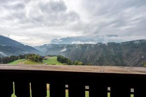 una panchina di legno con vista su una valle di montagna. di Ferienwohnung Gatscherhof a Luson