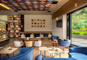 een restaurant met blauwe meubels en tafels en stoelen bij O by Tamara Coimbatore in Coimbatore