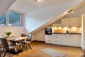 una cucina e una sala da pranzo con tavolo di Apartement Bens Auszeit Top 6 a Umhausen