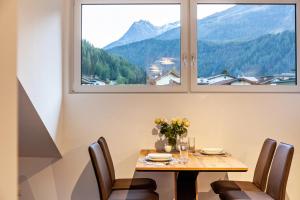 una sala da pranzo con tavolo, sedie e finestra di Apartement Bens Auszeit Top 6 a Umhausen