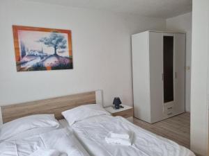 una camera con un letto bianco e un dipinto sul muro di Hotel Pension Anke a Bodenmais