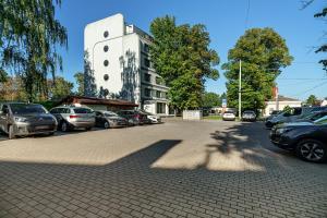 un parcheggio con auto parcheggiate di fronte a un edificio di Rija VEF Hotel with FREE Parking a Riga