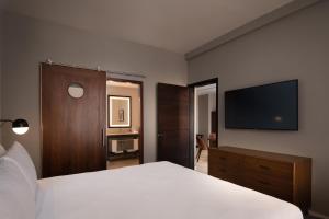 - une chambre avec un lit blanc et une télévision à écran plat dans l'établissement Four Points by Sheraton , à Punta Cana