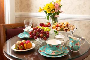 een tafel met borden en een vaas met bloemen bij America's Cup Inn Newport in Newport