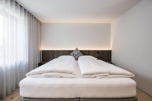 una camera da letto con un letto bianco e asciugamani bianchi di Luis Chalet a Brunico