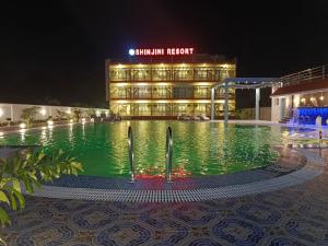 un hotel con piscina di fronte a un edificio di Shinjini Resort a Mandarmoni