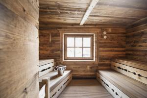 um quarto com paredes e bancos de madeira e uma janela em Hotel Hoferwirt em Neustift im Stubaital