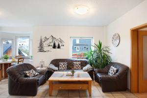 ein Wohnzimmer mit 2 Ledersofas und einem Tisch in der Unterkunft Kirsten's Hike n Bike Ferienwohnung in Schmallenberg