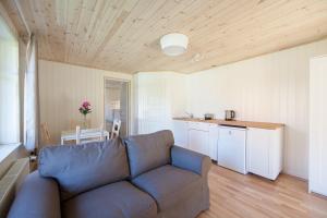 a living room with a couch and a kitchen at Pervalkos vetrunges in Neringa