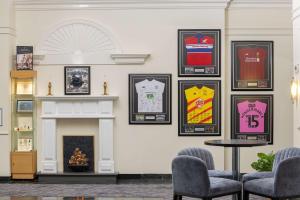 a room with a fireplace and pictures on the wall at Hilton Northampton Hotel in Northampton