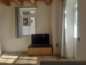 a living room with a tv on a box in front of a window at Appartamento Vale e Schena Cortina D'Ampezzo in San Vito di Cadore