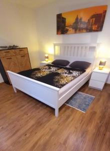 a large white bed in a room with two tables at Casa Rustica in Magadino