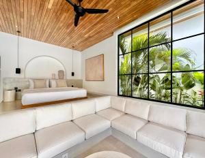 a living room with a couch and a bed at The Suites by The Young Villas in Uluwatu