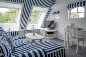 een woonkamer met blauw en wit gestreept meubilair bij Inselhotel Arfsten in Wyk auf Föhr