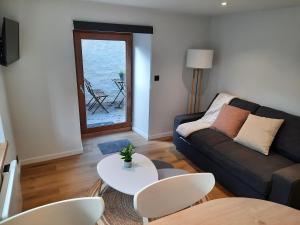 uma sala de estar com um sofá e uma mesa em Bulle en Ville Maisonnette de charme em Spa