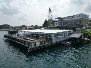 ein Haus auf einer Anlegestelle im Wasser in der Unterkunft PURNAMA BALIGE HOTEL in Balige