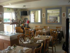 une salle à manger avec des tables et des chaises dans un restaurant dans l'établissement Les Augustines, à Quend