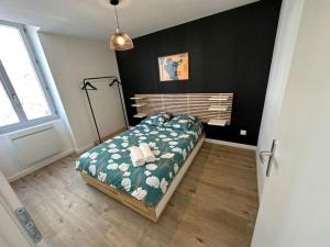 een slaapkamer met een bed met een groen dekbed bij Appartement JAZZ Vienne nord in Vienne