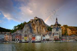 a city with a rainbow in the middle of the water at ibis Dinant Centre in Dinant