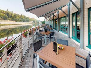 a deck with tables and chairs on a boat at ibis Dinant Centre in Dinant