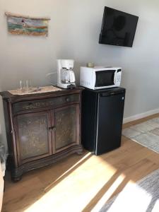 een magnetron op een houten kast met een koelkast bij Sand Dollar in Indian Harbour