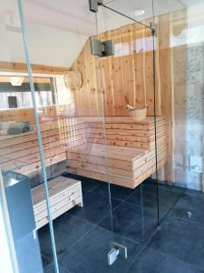 un sauna aux murs en bois et une cabine de douche en verre dans l'établissement Ferienhaus Asterbach, à Gosau