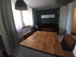 a dining room with a wooden table and chairs at Na Sadowej in Grodzisk Mazowiecki