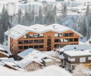 un lodge en la nieve con techos nevados en Revier Mountain Lodge Adelboden, en Adelboden