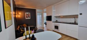 una cucina con armadi bianchi e un tavolo bianco in una stanza di Modern, fully equipped flat a Copenaghen