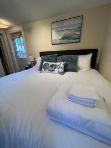 - une chambre avec un lit blanc et des serviettes dans l'établissement Bright & Spacious 1 BR- King Bed & Private Yard, à Providence