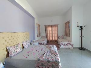 1 dormitorio con 1 cama y 1 cruz en la pared en Henchir ejdoud, en Kairouan