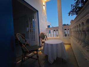 una mesa y sillas en el balcón de una casa en Henchir ejdoud, en Kairouan