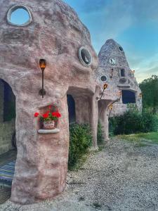 Una casa de piedra con una maceta de flores. en Anemoessa, en Synikia Mesi Trikalon